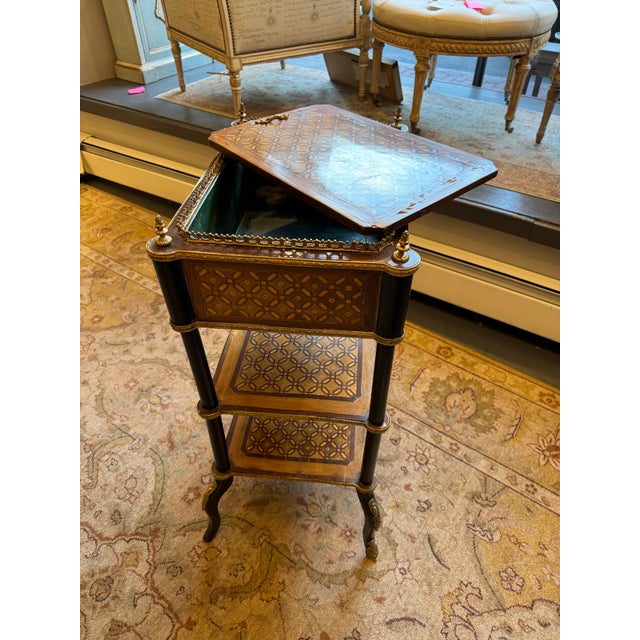 This is a French antique three tier parquetry planter table. It has fruitwood. It has brass ormolu accents. It is missing...
