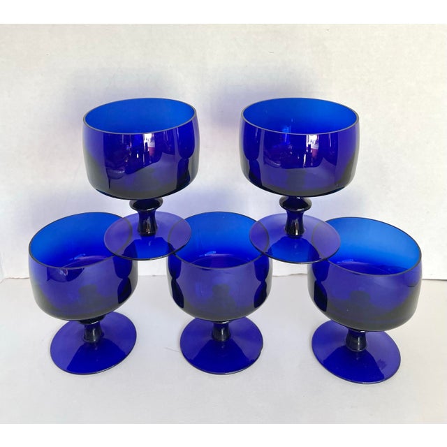 Here is a fabulous set of five vintage cobalt blue stemmed glasses, likely dating to the mid-20th century. The rich,...