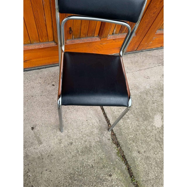 Set of Italian modernist Bauhaus-style dining chairs with chrome tubular steel frames and black faux leather seats....