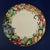 A pair of nature inspired plates decorated with lush flowers and fauna such as ocelots, zebras and macaws on a white...