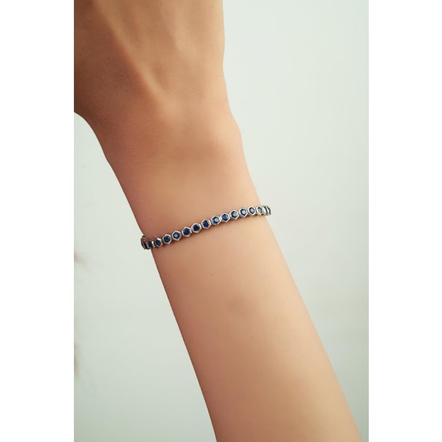 This tennis bracelet features 5.54 carats of natural blue sapphires set in 14K white gold. Each sapphire measuring...