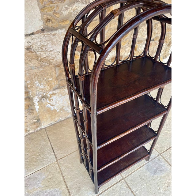 Vintage, bamboo and rattan, 4-tiered floor shelf / bookcase circa 1960's. Piece has four shelves made of a dark-brown...