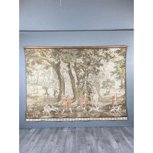 Large decorative wall tapestry depicting an elegant hunting scene in a wooded landscape, featuring figures in period...