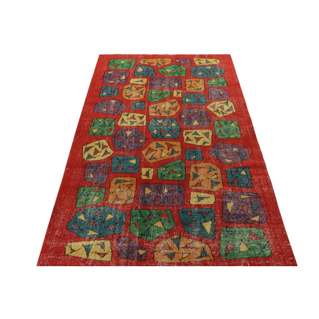 Hand-knotted in wool circa 1960-1970, a distressed style mid-century modern rug from the celebrated artist Zeki Muren with...