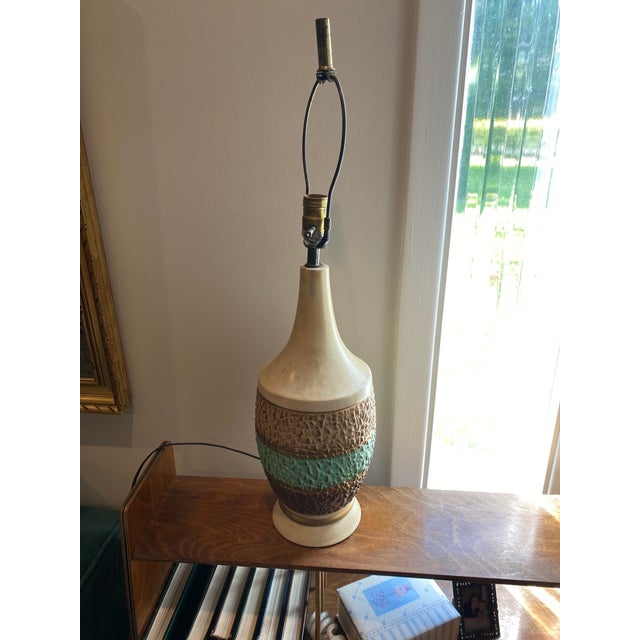 Add a touch of mid-century charm to your space with this beautifully textured ceramic table lamp. Featuring a sculptural...