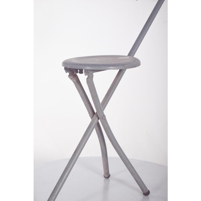 This ingenious folding seat, designed with a cane-like handle for easy transport, was created for the Brussels World’s...