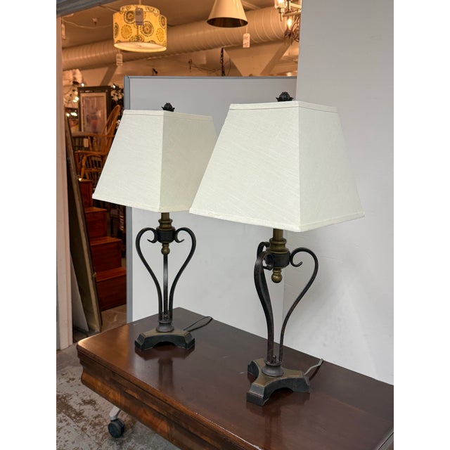 Design Plus Gallery presents a Pair of Vintage French Country Table Lamps. This matching pair has scroll-form metal frames...