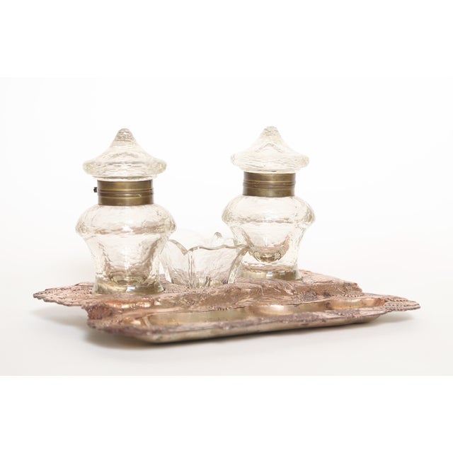 Antique coppered Japonais Revival inkstand with two ink pots and a stamp holder. The border of the base is in relief and...