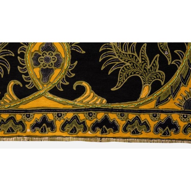 Indonesian cloth finely decorated with floreal motives in yellow and green on a dark blue background. The item is not...