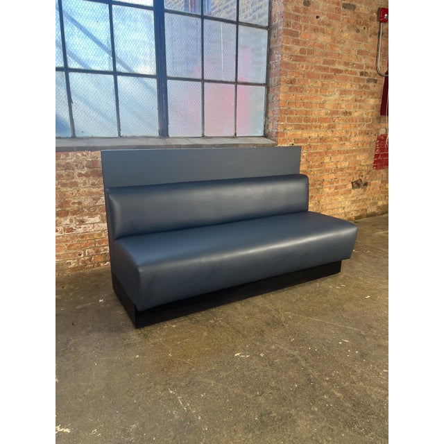 A sleek, high-back banquette bench attributed to Martin Brattrud, reupholstered in new leather in a deep steel blue/slate...