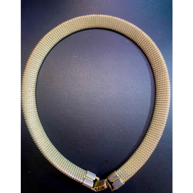 A flexible, interlocking tubular mesh/coil (tubogas style) over a hollow core, allowing the choker to maintain its...