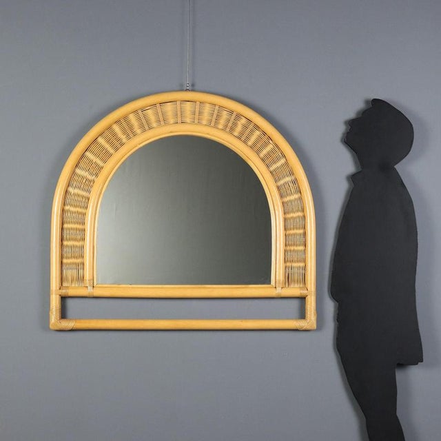 Wall mirror crafted in the 1980s, featuring a bamboo frame that embodies the charm of the natural design typical of that...