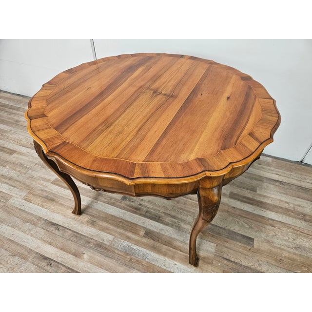 An elegant round table in solid walnut, crafted in the Baroque style and characterized by rich, harmonious lines that...