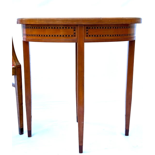 This oval table originates from a coordinated early 20th-century salon set with matching chairs featuring similar inlay...