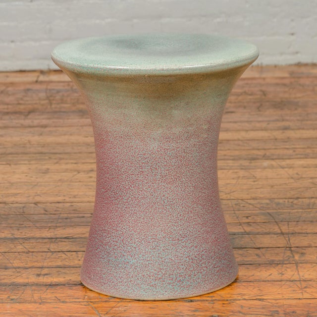 A Chinese contemporary artisan hand painted and glazed garden seat with green and pink/purple tones. Attracting our...