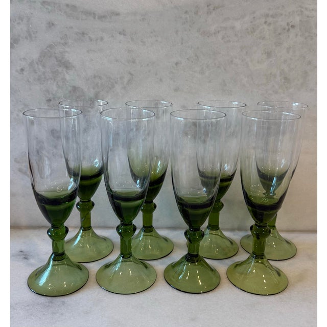 Set of 8 handblown green wine glasses with beautiful detail on the step and a bell foot. Perfect for your holiday table.