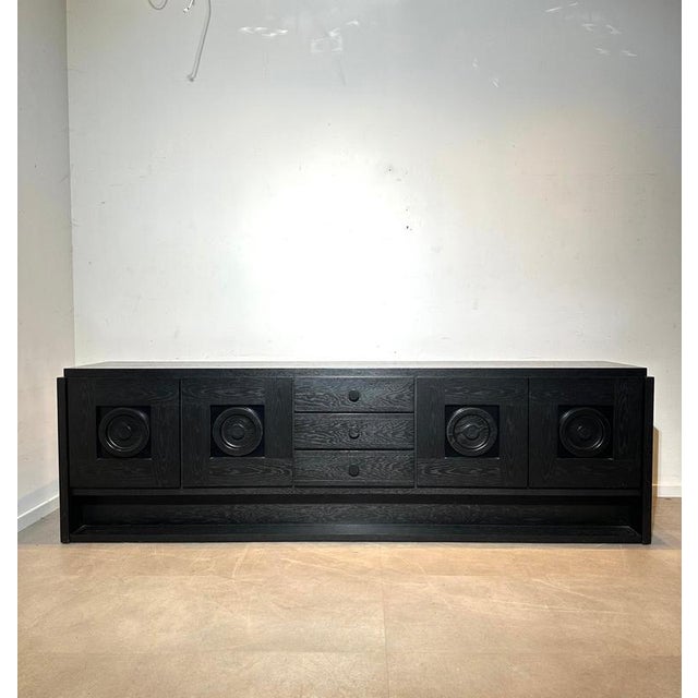 Monumental brutalist sideboard in black-stained oak with impressive sculpted circular door fronts. The long, low...
