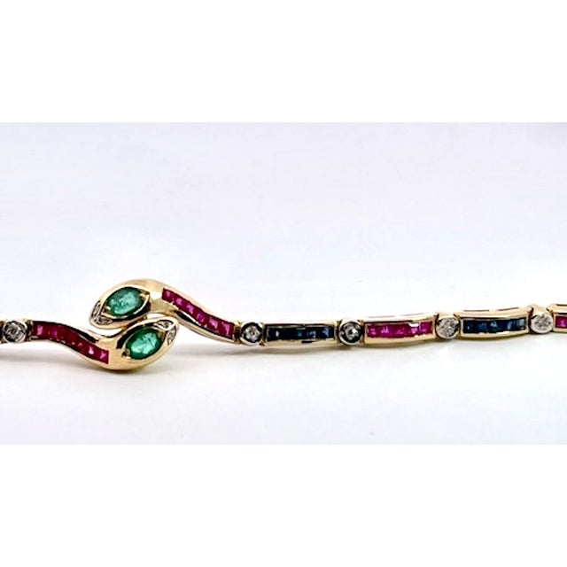 This is a stunning gold gemstone bracelet featuring a distinctive "toi et moi" (you and me) snake-inspired design at its...