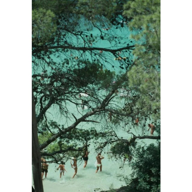 Beach Near Portinatx 1989 by Slim Aarons Slim Aarons Limited Estate Edition Holidaymakers seen through the trees, at a...