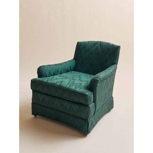 These armchairs feature a classic, tailored silhouette upholstered in a rich emerald green moiré style fabric with subtle...