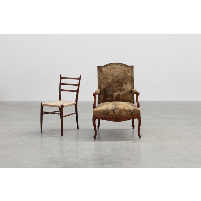 A richly detailed French walnut armchair from around 1880, offering decorators an elegant blend of sculptural woodworking...