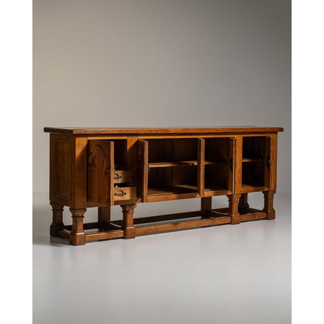 Carved walnut gothic-arch buffet in Rich Walnut Brown. Its rich walnut brown finish sets off four arched-panel doors,...