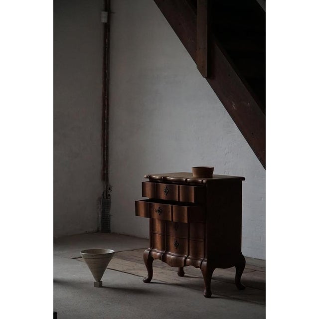 Beautiful small baroque style chest of drawers, crafted in the early 20th century. The piece features elegant serpentine...