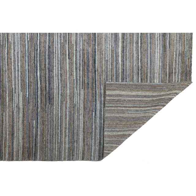 Elevate your space with this sophisticated modern Indian wool rug, featuring a dynamic, hand-knotted construction. Defined...