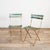A pair of classic French slatted folding garden chairs. The wooden slats are in their original green/white paint with a...