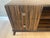 This contemporary macassar ebony console has versatile open center shelves with two drawers on each side, brushed silver...