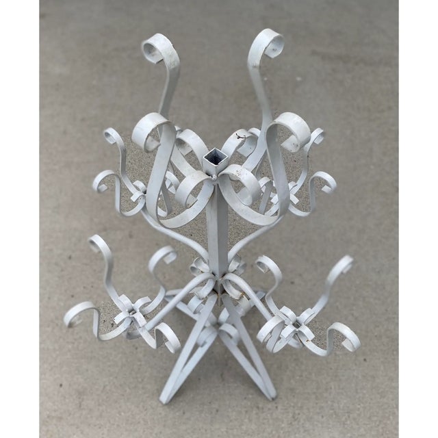 A wonderful 1970’s Mexican wrought iron plant stand that holds one 6” pot on the top and four 4” pots on the lower tier....