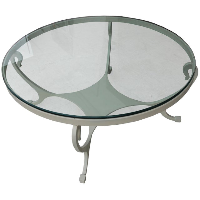 45" glass wrought iron coffee table Torch-cut wrought iron with graceful curves. Glass top. Base is lacquered in off white.