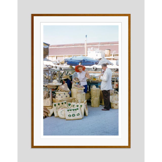 Nassau Straw Market by Toni Frissell Tourists browse handmade woven bags and hats at the iconic Nassau Straw Market in the...