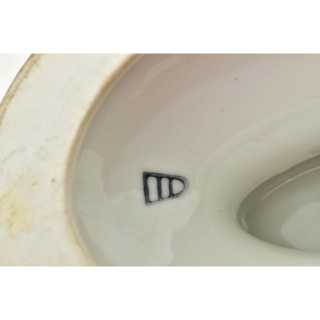 Porcelain vase with cover (urn) of oval shape, finely painted, depicting a female by the seaside on one side, and a wooded...