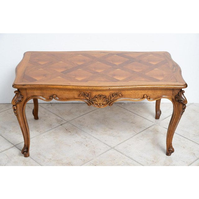 A low coffee table made of solid French walnut, dating from the first half of the 20th century. The tabletop, featuring...