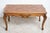A low coffee table made of solid French walnut, dating from the first half of the 20th century. The tabletop, featuring...