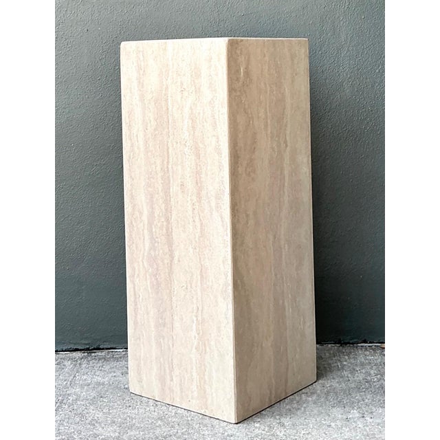 This refined vintage travertine pedestal column exemplifies the timeless appeal of natural stone and understated...