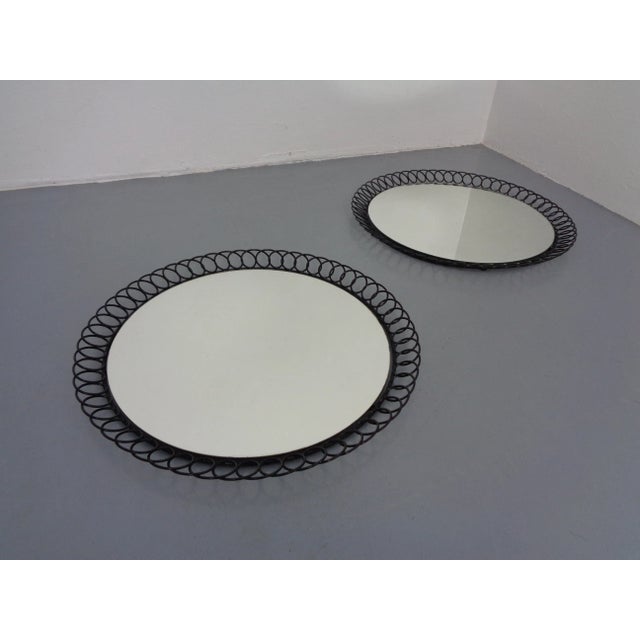 Round mirror with black lacquered metal frame from the 1960s.