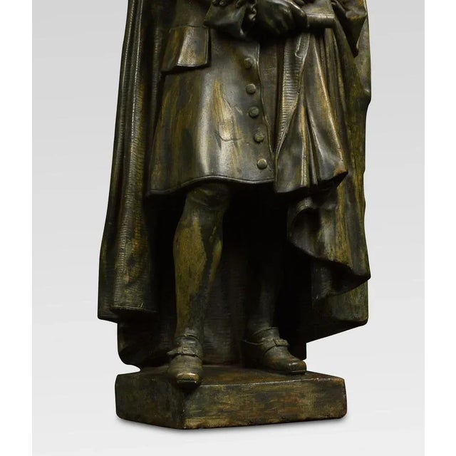 A pair of 19th century chalked bronzed figures in typical dress raised up on square bases Dimensions Height 24 Inches...