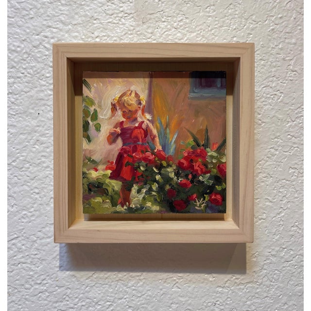 This artwork captures a young girl in a vibrant red dress, immersed in a lush garden filled with blooming roses. The soft...