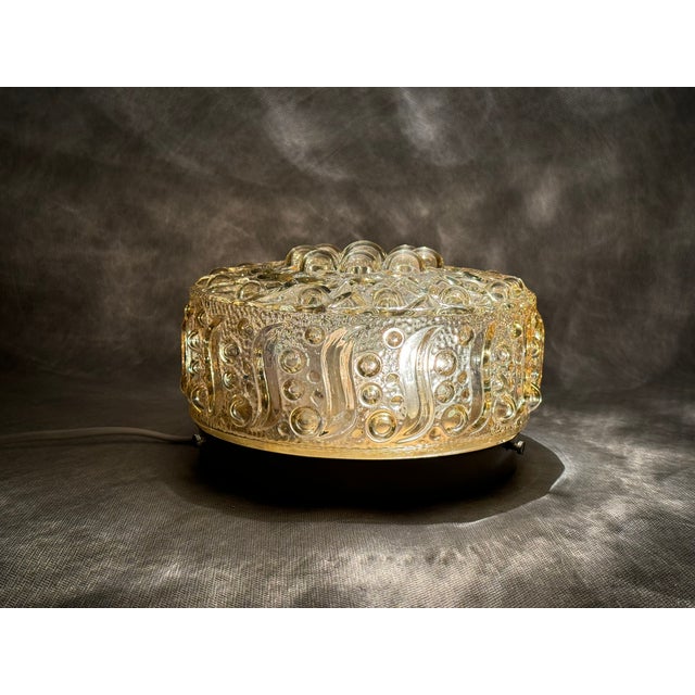 Vintage ceiling light made of pressed glass in a warm amber tone. Sculptural bubble and wave relief typical of European...