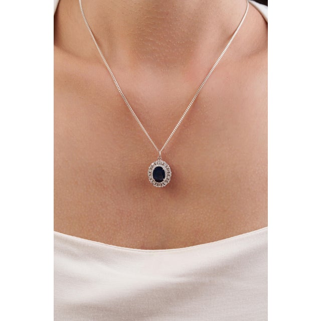 This Classic Halo Pendant showcase 2.78-carat natural blue sapphire, set in 14k white gold. The measuring 10 x 7.5 mm,...