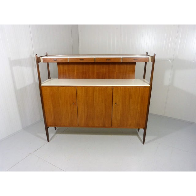 Highboard by Deutsche Werkstatten, Germany. (marked) Teak wood with white laminated tops. Under the upper top 4 small...
