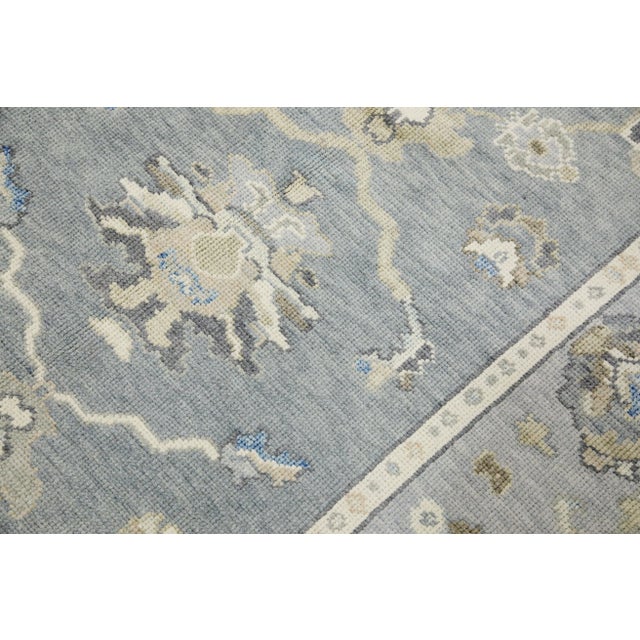 This modern Turkish Oushak rug is a stunning piece of art that has been handwoven using traditional techniques by skilled...