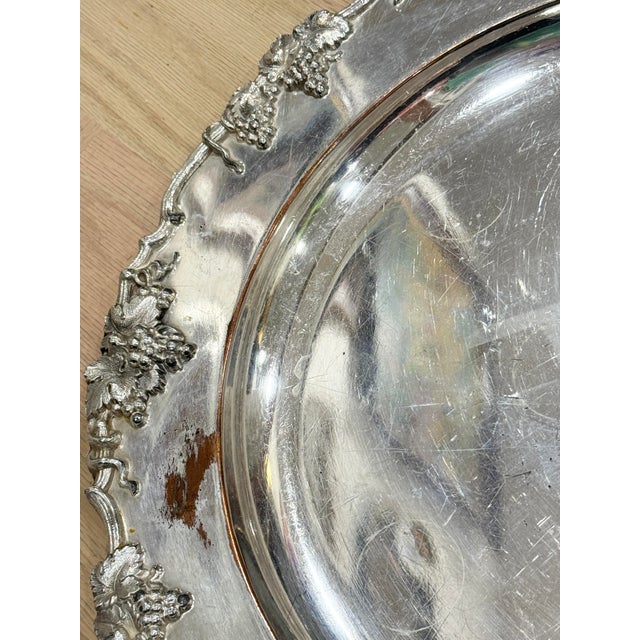 Vintage silverplate serving tray. Features an ornate grape vine design. Shows noticeable wear. Still a nice piece to use...