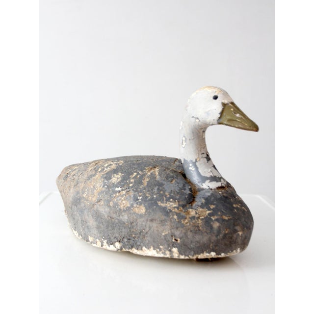 A mid-century swan decoy featuring a lightweight foam body with a carved head and neck, finished in a heavily weathered...