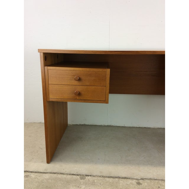 This Danish Modern writing desk features pressed wood construction, teak veneer with original finish, two dovetailed...