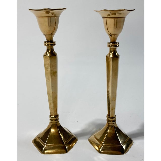 Large elegant brass candle holders with hex bases and angular columns. Topped by fluid tulip shape to hold single taper...