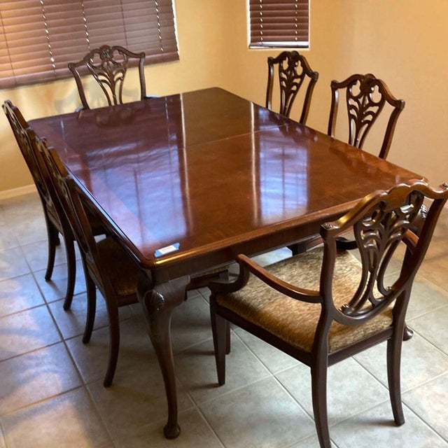 This elegant Henredon dining set includes a large rectangular wood table and 6 matching chairs, featuring classic carved...