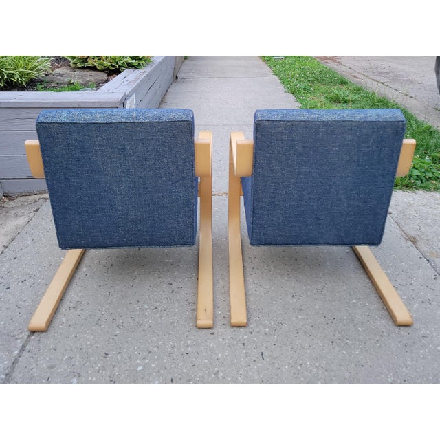 Newly reupholstered in a stunning blue nubby woven fabric with yellow undertones, this pair of birch bentwood Model 402...
